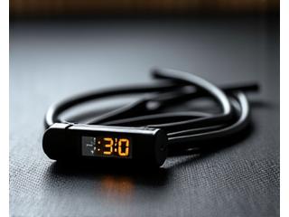 Ein Springseil und eine Stoppuhr auf einem Sportboden, bereit für ein HIIT-Workout.